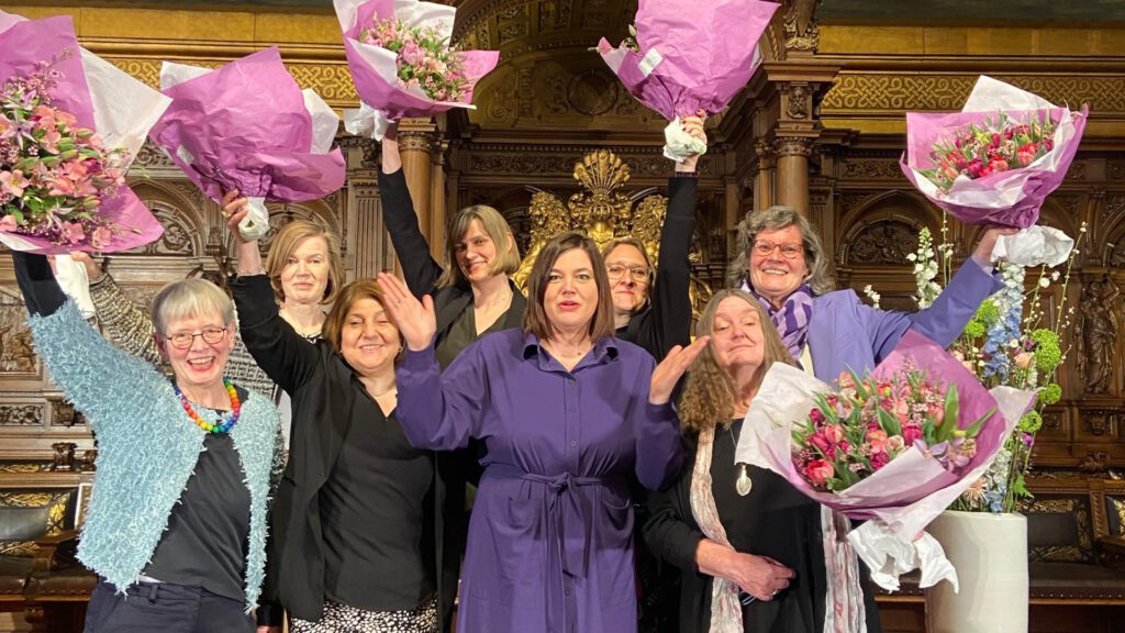 Gruppenfoto des Vorstandes des Landesfrauenrats Hamburg e.V. mit Hamburgs Zweiter Bürgermeisterin Katharina Fegebank. Alle recken feierlich Blumensträuße in die Höhe.