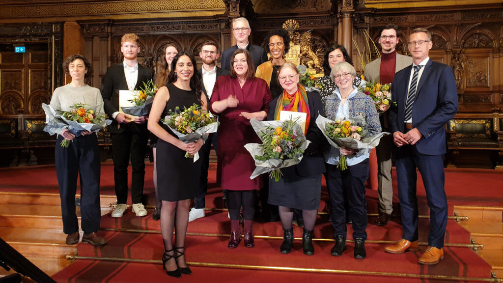 Eine Grupppe von Personen posiert im Hamburger Rathaus mit Blumensträußen, darunter Hamburgs Zweite Bürgermeisterin Katharina Fegebank, Ehrenpreisträgerin Prof. Dr. Bessenrodt-Weberpals und Eva Burgdorf aus dem Vorstand des Landesfrauenrat Hamburg e.V.